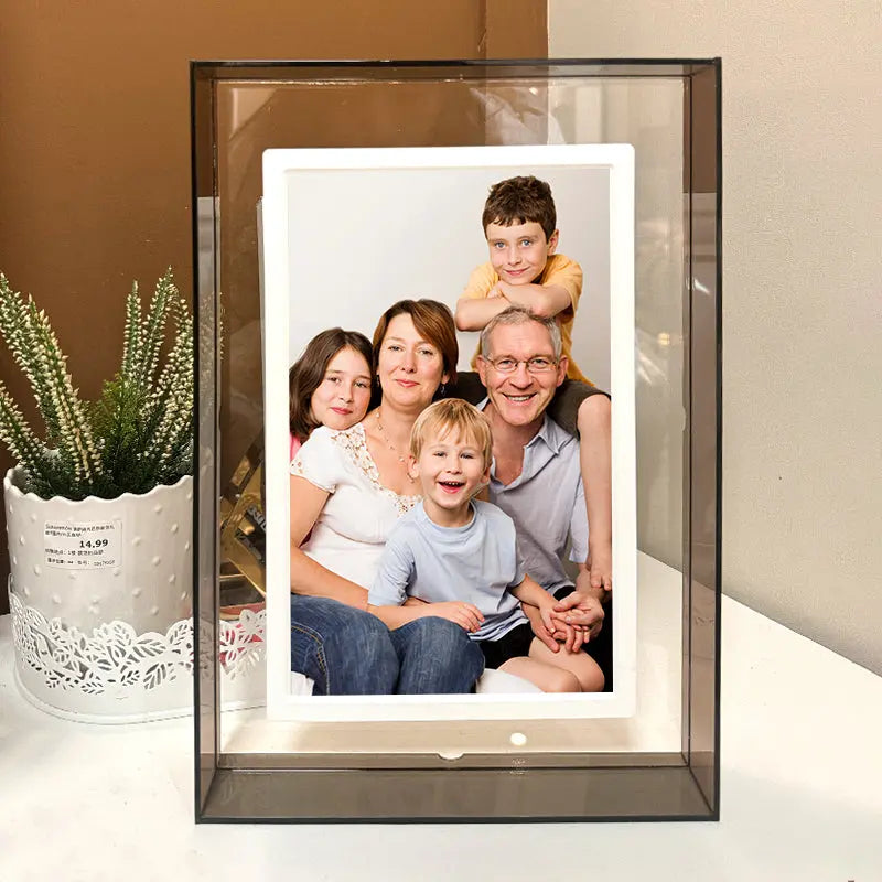 A family photo displayed in a clear glass frame, showcasing smiling faces and a warm, joyful atmosphere.